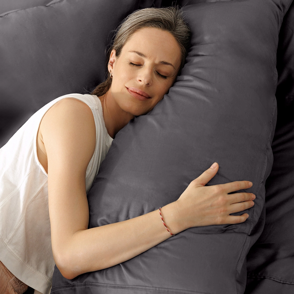 Woman hugging a soft grey pillow comfortably