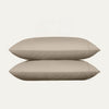 Two beige pillows stacked on a white background