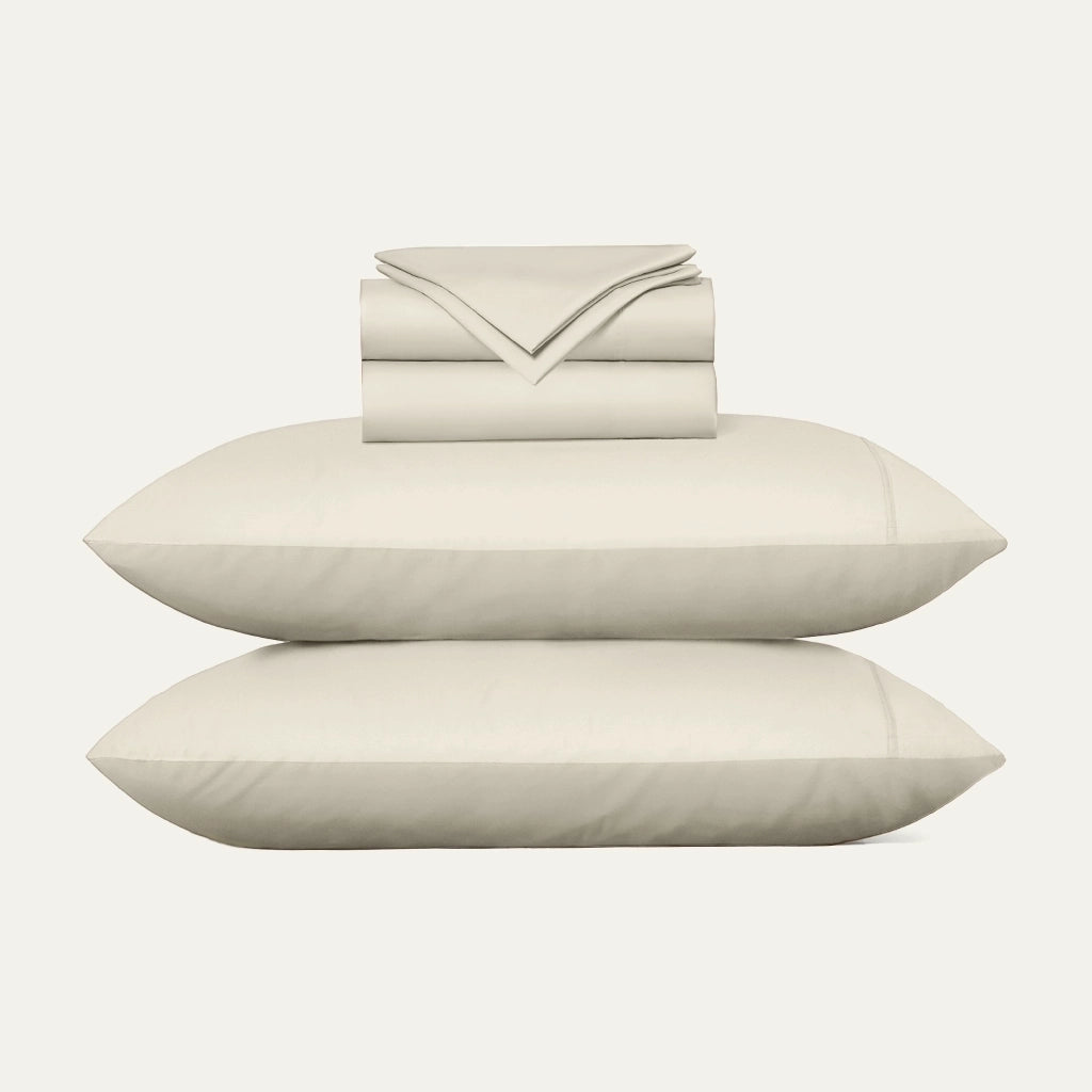 Beige bed sheets and pillows on a white background
