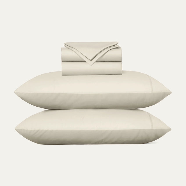 Beige bed sheets and pillows on a white background