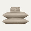 Beige bed sheets and pillows on a white background