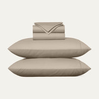 Beige bed sheets and pillows on a white background