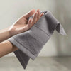 Person holding a gray towel with a blurred background