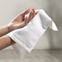 Person holding a white towel with a blurred background